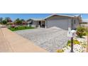 Well-maintained home featuring a brick-paved driveway and lush landscaping, offering great curb appeal at 5122 E Emerald Cir, Mesa, AZ 85206