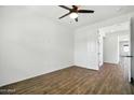 A bright bedroom with wood flooring, ceiling fan and views into the hallway at 5956 N 188Th Ln, Litchfield Park, AZ 85340