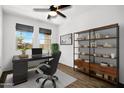 Bright home office featuring a ceiling fan, a storage shelf and a modern black desk at 5956 N 188Th Ln, Litchfield Park, AZ 85340
