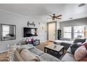 Inviting living room featuring a large sectional sofa, mounted TV, and a ceiling fan at 6328 W Fawn Dr, Laveen, AZ 85339