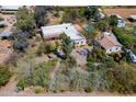Aerial view of a white roof home with lush greenery, pool and outbuildings on a sprawling lot at 6418 E Sunnyside Dr, Scottsdale, AZ 85254