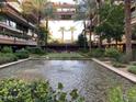 A beautiful pond with fountains, landscaping, and chairs is surrounded by an open-air building at 7157 E Rancho Vista Dr # 1004, Scottsdale, AZ 85251