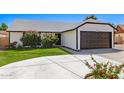 Charming single-story home with a well-manicured lawn and attached two-car garage on a sunny day at 7231 W Sierra Vista Dr, Glendale, AZ 85303