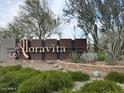 Welcoming Aloravita community sign surrounded by lush landscaping and desert plants at 7703 W Saddlehorn Rd, Peoria, AZ 85383