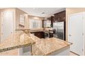 Kitchen features dark cabinetry, granite countertops, and stainless steel appliances at 8113 W Groom Creek Rd, Phoenix, AZ 85043