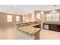 Open floor plan with granite kitchen bar, tile flooring, and ample natural light at 8113 W Groom Creek Rd, Phoenix, AZ 85043