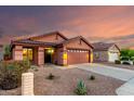 Inviting single-story home with low-maintenance landscaping, a two-car garage, and a warm, welcoming facade at 8433 E Natal Cir, Mesa, AZ 85209