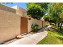 Home exterior with a private entry gate, block wall, and sidewalk lined with mature landscaping at 8818 N 47Th Ln, Glendale, AZ 85302