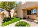 Attractive home facade featuring lush artificial grass, charming landscape, and a secure front entry at 8818 N 47Th Ln, Glendale, AZ 85302