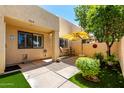 Relaxing walled patio with umbrella, outdoor seating, manicured bushes, and artificial turf at 8818 N 47Th Ln, Glendale, AZ 85302