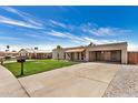 Street view of a single-story home with light brick and an open carport, set against a blue sky at 908 S Kachina --, Mesa, AZ 85204