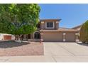 Charming home with a three car garage and a large shade tree in the front yard at 991 N Quail Ln, Gilbert, AZ 85233