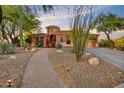 Charming single-story home with desert landscaping and a paved walkway to the front door at 10694 E Redfield Rd, Scottsdale, AZ 85255