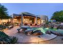 Desert home featuring a beautiful backyard pool with unique rock waterfall, patio seating, and desert landscaping at 10822 E Prospect Point Dr, Scottsdale, AZ 85262