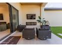 Relaxing outdoor patio with sleek furniture, a modern fireplace, and a mounted television for entertainment at 10918 W Dove Roost Rd, Queen Creek, AZ 85144