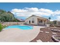 Inviting backyard with a pool, rock waterfall, fire pit, and desert landscaping at 12626 W Windsor Ave, Avondale, AZ 85392