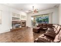 Cozy living room with built-in shelves, a fireplace, and a sliding glass door to the backyard at 12702 W Dove Wing Way, Peoria, AZ 85383