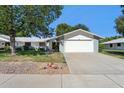 Charming single-story home with a well-maintained lawn, mature trees, and a two-car garage at 12726 W Copperstone Dr, Sun City West, AZ 85375