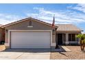 A close-up of an exterior elevation with a two-car garage and an American flag at 15047 W Kings Dr, Surprise, AZ 85374