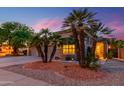 Charming home featuring desert landscaping with palm trees and a well-maintained lawn at 17710 W Buena Vista Dr, Surprise, AZ 85374