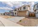 Welcoming two-story home showcasing desert landscaping, a two-car garage, and a charming front facade with shuttered windows at 18383 W Monte Lindo Ln, Surprise, AZ 85387