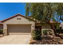 Charming home with a two-car garage, desert landscaping, and a beautiful mature shade tree at 19963 N Window Rock Dr, Surprise, AZ 85374