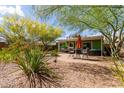 Cozy backyard patio with outdoor seating, an umbrella, desert landscaping, and a well-maintained lawn at 2231 E Weldon Ave, Phoenix, AZ 85016