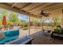 Relaxing covered patio with a ceiling fan, outdoor seating, a decorative rug, and vibrant plants at 2231 E Weldon Ave, Phoenix, AZ 85016