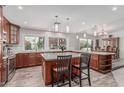 Well-lit kitchen with an island with barstool seating and a pass-through to the dining area at 2254 E Becker Ln, Phoenix, AZ 85028