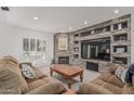 Open living room featuring a stone wall entertainment center, plush seating, and natural light at 2254 E Becker Ln, Phoenix, AZ 85028