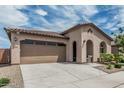 Inviting home featuring an attached two-car garage, neutral stucco siding, and beautiful desert landscaping at 23068 E Stacey Rd, Queen Creek, AZ 85142