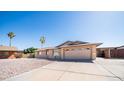 Attractive single-story home featuring desert landscaping, a two-car garage, and mature trees at 2337 E Riviera Dr, Tempe, AZ 85282