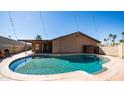 Backyard with a sparkling pool, covered patio, and lush greenery, perfect for outdoor enjoyment at 2337 E Riviera Dr, Tempe, AZ 85282