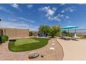 Backyard features a putting green, seating area, mature landscaping, and desert views at 2701 N Black Rock Rd, Buckeye, AZ 85396