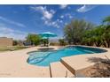 Gorgeous pool with desert views, privacy fence, tanning ledge, and lush landscaping at 2701 N Black Rock Rd, Buckeye, AZ 85396