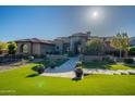 Impressive home with vibrant green lawn, decorative potted plants, and a paved path to the stunning front entrance at 3118 W Glenhaven Dr, Phoenix, AZ 85045