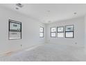 A spacious room with black-framed windows awaits your personal touch, ready for transformation at 3335 W Desert Dawn Dr, Phoenix, AZ 85083