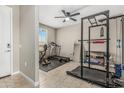 Spacious workout room with tile floors, ceiling fan, and natural light, ideal for fitness enthusiasts at 37645 W Santa Clara Ave, Maricopa, AZ 85138