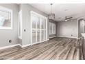 Large living room features wood-look tile floors, neutral walls, ceiling fan and many shuttered windows and sliding doors at 42424 N Gavilan Peak Pkwy # 24206, Anthem, AZ 85086