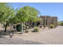 Attractive desert-style home with native landscaping, mature trees, and a brick-paved driveway at 4772 E Agave Ln, Cave Creek, AZ 85331