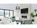 Bright living room featuring a modern fireplace, comfortable seating, and large windows with desert views at 5919 E Corrine Dr, Scottsdale, AZ 85254