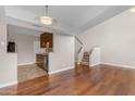 Open concept living space with hardwood floors leading to a kitchen area and a staircase to the upper level at 7835 E Glenrosa Ave # 13, Scottsdale, AZ 85251