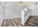 Bright living room with wood-look floors, staircase, and a large window showcasing natural light at 8037 W Mohave St, Phoenix, AZ 85043