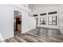 View of the living room with tall ceilings, wood floors, and an arched doorway leading to kitchen at 8037 W Mohave St, Phoenix, AZ 85043