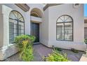 Stylish front entrance framed by arched windows and lush desert landscaping at 8136 E Cortez Dr, Scottsdale, AZ 85260
