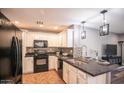 Well-lit kitchen with granite countertops, stainless steel sink, tile backsplash, and modern appliances at 8657 E Capri Ave, Mesa, AZ 85208