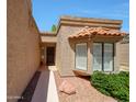 This home features a private walkway, desert landscaping, and a charming tile-roofed bay window at 9512 W Mcrae Way, Peoria, AZ 85382
