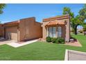 Inviting front exterior showcasing a well-manicured lawn, desert landscaping, and a tile roof at 9512 W Mcrae Way, Peoria, AZ 85382
