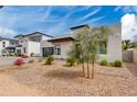 Landscaped modern home with a paver driveway and a black framed glass garage door at 100 W Northern Ave # 8, Phoenix, AZ 85021