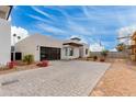 Modern home with a paver driveway, desert landscaping, and glass garage door at 100 W Northern Ave # 8, Phoenix, AZ 85021